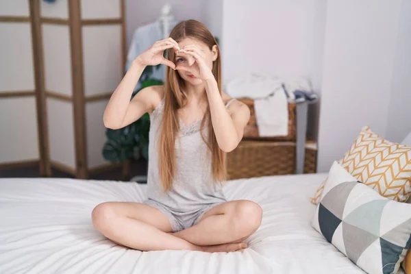 Young Caucasian Woman Doing Heart Gesture Sitting Bed Bedroom — Stockfoto