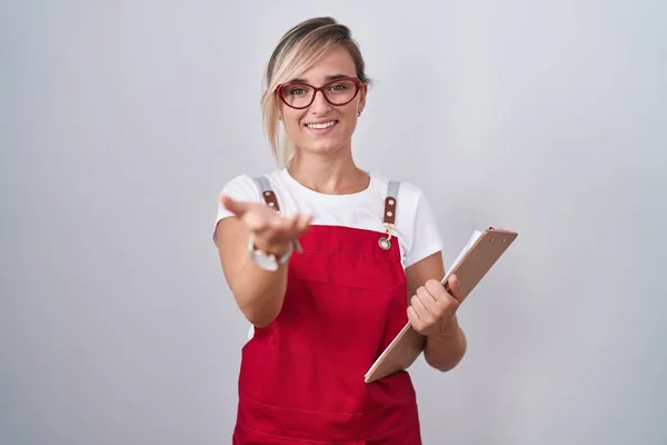 Jovem Loira Mulher Vestindo Garçom Uniforme Segurando Prancheta Sorrindo Alegre — Fotografia de Stock