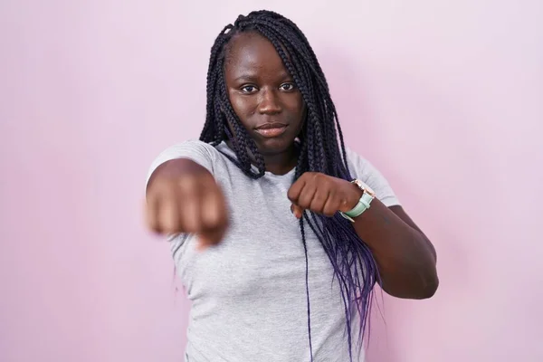 Mujer Africana Joven Pie Sobre Fondo Rosa Golpeando Puño Para —  Fotos de Stock