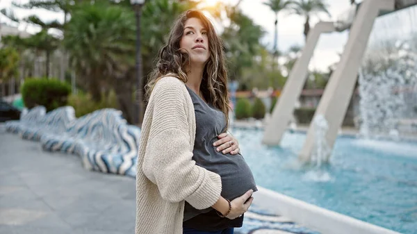 Jonge Zwangere Vrouw Staan Met Ernstige Uitdrukking Aanraken Buik Park — Stockfoto