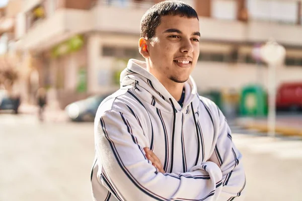 stock image Young man smiling confident standing with arms crossed gesture at street