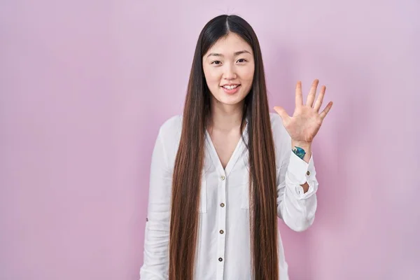 Chinese Jonge Vrouw Staan Roze Achtergrond Tonen Wijzen Met Vingers — Stockfoto
