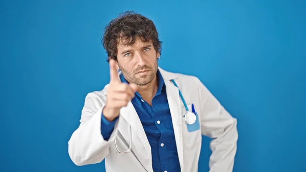 Νεαρός Ισπανός Γιατρός Στέκεται Σοβαρή Έκφραση Δείχνοντας Δάχτυλο Πάνω Από — Φωτογραφία Αρχείου