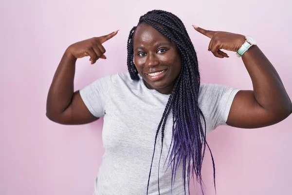 Jonge Afrikaanse Vrouw Staat Roze Achtergrond Glimlachend Wijzend Naar Het — Stockfoto