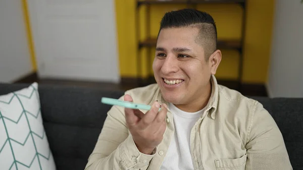Ung Latinamerikansk Man Skicka Röstmeddelande Med Smartphone Sitter Soffan Hemma — Stockfoto