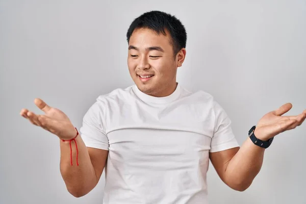 Молодой Китаец Стоит Белом Фоне Улыбается Показывая Обе Руки Открытыми — стоковое фото