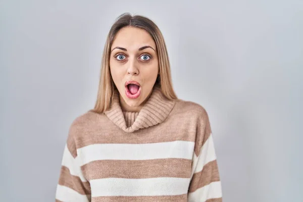 stock image Young blonde woman wearing turtleneck sweater over isolated background afraid and shocked with surprise and amazed expression, fear and excited face. 