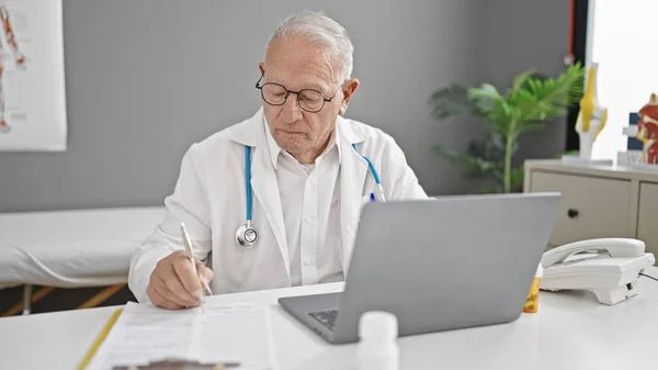 Starszy Siwowłosy Lekarz Korzystający Laptopa Pracującego Klinice — Zdjęcie stockowe