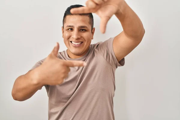 Jovem Hispânico Sobre Fundo Branco Sorrindo Fazendo Quadro Com Mãos — Fotografia de Stock