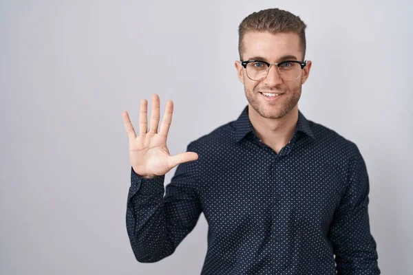 年轻的高加索人男子站在孤立的背景下 带着自信和快乐的微笑 用五号手指指指着 — 图库照片