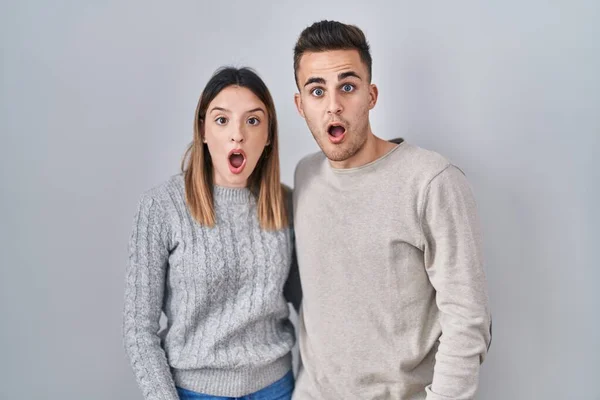 Young Hispanic Couple Standing White Background Shock Face Looking Skeptical — 图库照片