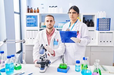 Laboratuvarda çalışan iki genç insan düşünce tarzları ve ayık yüz ifadeleri ile kendilerine güveniyorlar. 