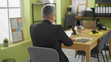 Genç İspanyol iş adamı ofiste belge okuyor.