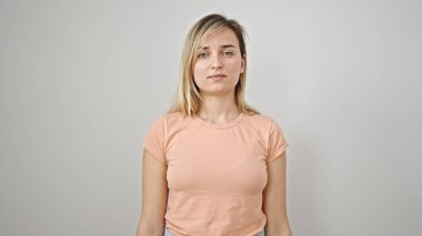 Young blonde woman standing with serious expression over isolated white background