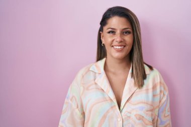 Blonde woman standing over pink background with a happy and cool smile on face. lucky person. 