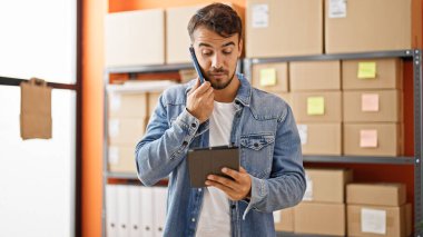 Young hispanic man ecommerce business worker smiling confident at office