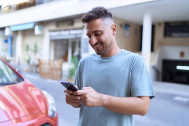 Sokakta akıllı telefon kullanan, kendine güvenen genç bir İspanyol.