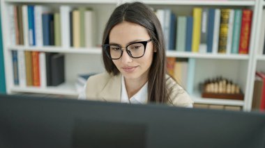 Üniversite sınıfında bilgisayar kullanan güzel İspanyol bir kız öğrenci.