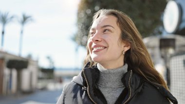 Young caucasian woman smiling confident looking to the sky at street