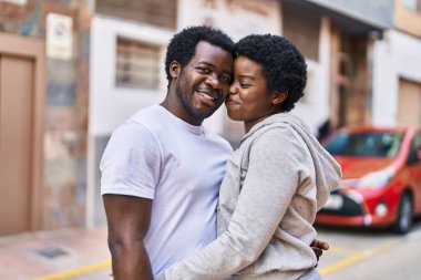 African american man and woman couple smiling confident hugging each other at street