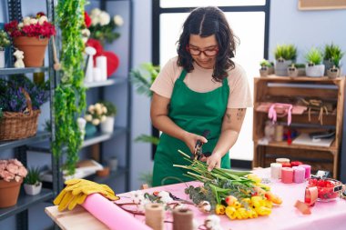 Young woman florist make bouquet of flowers at florist