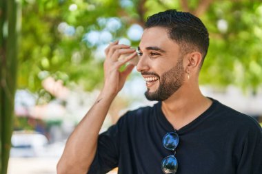 Genç Arap adam parktaki akıllı telefondan kendine güvenen bir sesli mesaj dinliyor.