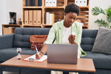 Psikoloji merkezinde telekonksiyon reçetesi yazan Afrikalı Amerikalı kadın psikolog.