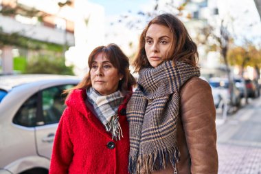 İki kadın anne ve kız sokakta rahat bir ifadeyle yan yana duruyorlar.