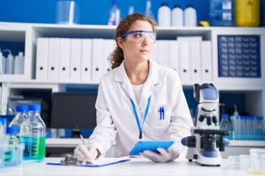 Genç, İspanyol asıllı, güzel bir bilim adamı. Laboratuvardaki belgelerde dokunmatik kağıt kullanıyor.