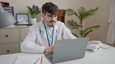 Genç İspanyol doktor klinikte internetten randevu alıyor.