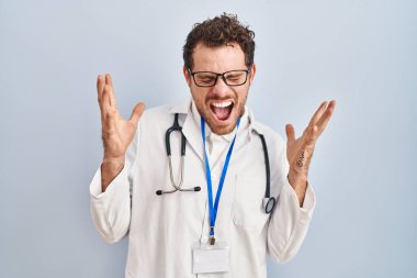 Doktor üniforması giyen genç İspanyol adam ve steteskop başarıyı kollarını kaldırmış ve gözlerini kapatmış heyecanla haykırarak çılgın ve çılgın bir şekilde kutluyor. Kazanan konsept 