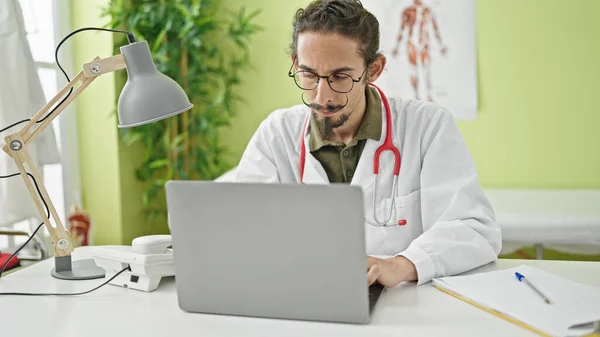 Young Hispanic Man Doctor Using Laptop Working Clinic — Fotografia de Stock