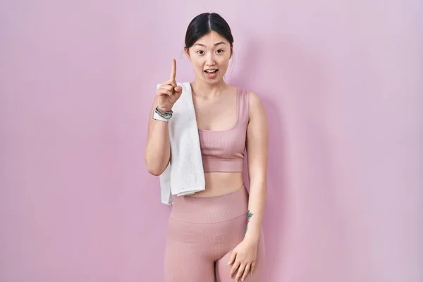 成功したアイデアで指を指すスポーツウェアとタオルを身に着けている中国の若い女性 興奮して幸せよ 第1位 — ストック写真