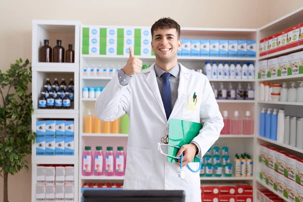 Joven Hombre Hispano Trabajando Farmacia Sosteniendo Estetoscopio Sonriendo Feliz Positivo — Foto de Stock