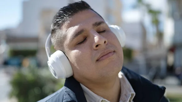 ストリートで音楽を聴いている若いヒスパニック系の男 — ストック写真