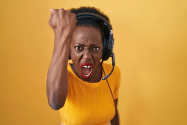 African Woman Curly Hair Standing Yellow Background Wearing Headphones Angry — Stock Photo, Image