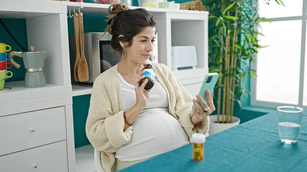 Jonge Zwangere Vrouw Met Online Medisch Consult Holding Pillen Eetkamer — Stockfoto