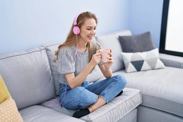 Jong Blond Vrouw Luisteren Naar Muziek Drinken Koffie Thuis — Stockfoto