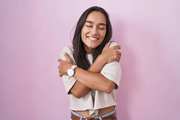 Mujer Hispana Joven Pie Sobre Fondo Rosa Abrazándose Feliz Positivo —  Fotos de Stock