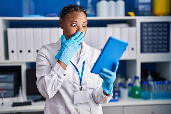 拿着辫子在科学家实验室工作的非洲裔美国妇女用手捂住嘴做视频通话 感到震惊和害怕犯错 惊讶的表情 — 图库照片