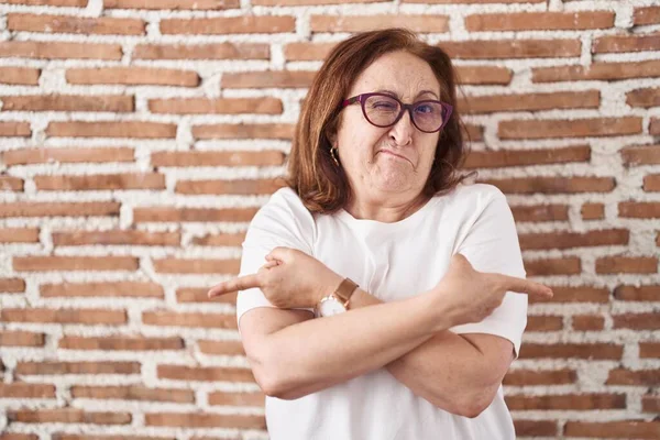 Senior Woman Glasses Standing Bricks Wall Pointing Both Sides Fingers — Stock Photo, Image