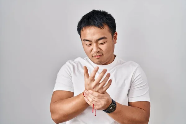 Beyaz Arka Planda Duran Genç Çinli Adam Ellerinde Parmaklarında Ağrı — Stok fotoğraf