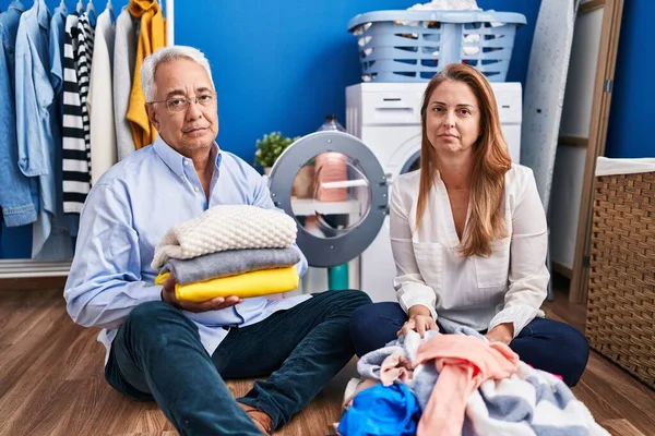 Middle Age Hispanic Couple Doing Laundry Sitting Floor Relaxed Serious — Stock Photo, Image
