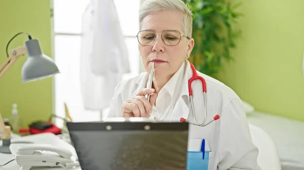 Orta Yaşlı Kır Saçlı Kadın Doktor Sağlık Raporlarını Okuyor Klinikte — Stok fotoğraf