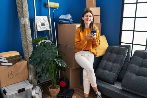 Young Blonde Woman Using Smartphone Sitting Sofa New Home — Fotografia de Stock