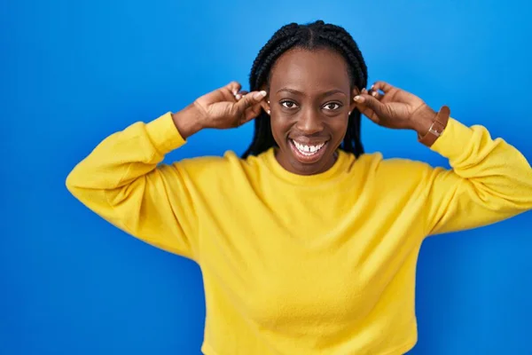 Beautiful Black Woman Standing Blue Background Smiling Pulling Ears Fingers — Stock Photo, Image