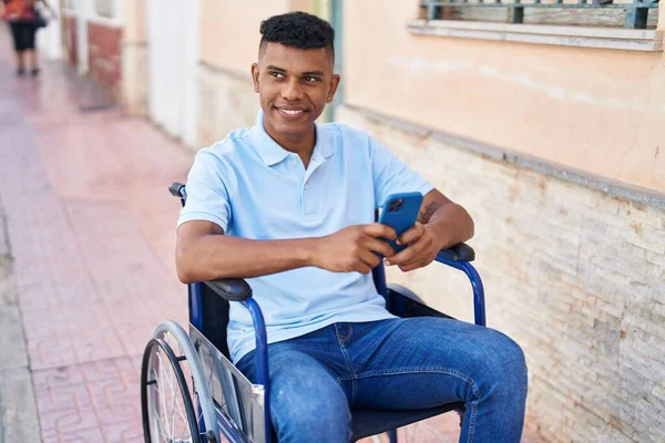 Sokakta Tekerlekli Sandalyede Oturan Akıllı Telefon Kullanan Genç Latin Adam — Stok fotoğraf