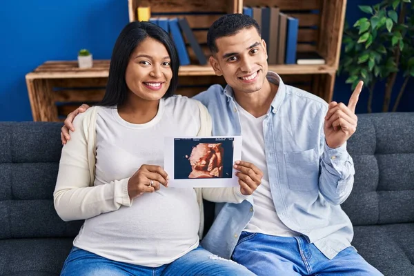 Jong Hispanic Paar Verwacht Een Baby Zitten Bank Tonen Baby — Stockfoto