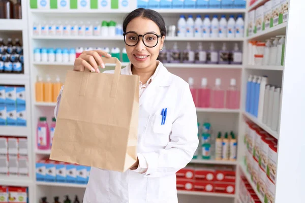 若いアラブ人女性薬剤師笑顔自信を持ってショッピングバッグで薬局 — ストック写真
