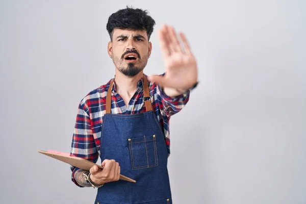 Jovem Hispânico Homem Com Barba Vestindo Avental Garçom Segurando Prancheta — Fotografia de Stock